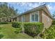 Tan single-story home with lush landscaping, well-maintained lawn, and bright white window shutters at 215 Foxglove Way, Deland, FL 32724