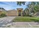 Charming single-story home boasts a manicured lawn, arched entryway, and attached two-car garage at 215 Foxglove Way, Deland, FL 32724