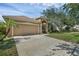 Charming single-story home boasts a manicured lawn, arched entryway, and attached two-car garage at 215 Foxglove Way, Deland, FL 32724