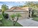Charming single-story home boasts a manicured lawn, arched entryway, and attached two-car garage at 215 Foxglove Way, Deland, FL 32724