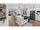 Modern kitchen with white cabinetry, stainless steel appliances, island, and black accents at 215 Foxglove Way, Deland, FL 32724