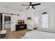 Bright main bedroom featuring a ceiling fan, hardwood floors, and a walk-in closet with a sliding barn door at 215 Foxglove Way, Deland, FL 32724