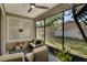 Inviting screened-in porch with wicker seating and an outdoor view of the manicured backyard at 215 Foxglove Way, Deland, FL 32724