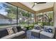 Relaxing screened-in porch with comfortable seating, stylish rug, and views of the backyard at 215 Foxglove Way, Deland, FL 32724