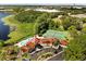 Expansive aerial view showcasing the community clubhouse, pool, tennis courts, and lush green surroundings near the lake at 236 Afton Sq # 109, Altamonte Springs, FL 32714