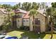 Multi-level condo building with red roofs, black metal balconies, mature landscaping, and palm trees at 236 Afton Sq # 109, Altamonte Springs, FL 32714