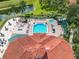An aerial view of a community pool and clubhouse with an adjacent lake and many palm trees at 2705 Grand Harbour Ct, Kissimmee, FL 34747