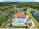 An aerial view of the community clubhouse, pool, and lake surrounded by lush landscaping at 2705 Grand Harbour Ct, Kissimmee, FL 34747