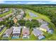 An aerial view of homes with screened pools and lush greenery, near a tranquil neighborhood pond at 2705 Grand Harbour Ct, Kissimmee, FL 34747