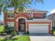 Two-story home featuring mature trees, lush landscaping, and a two-car garage at 2705 Grand Harbour Ct, Kissimmee, FL 34747