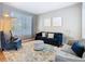 Cozy living room with modern furniture, hardwood flooring, and natural light from large windows at 2705 Grand Harbour Ct, Kissimmee, FL 34747