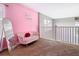 Cozy loft space featuring a pink accent wall, stylish seating, and natural light from a nearby window at 2705 Grand Harbour Ct, Kissimmee, FL 34747