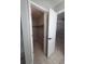 View of a well-organized closet, with an open door offering a glimpse into the adjacent bedroom, showcasing storage and layout at 2798 Beckwith St, Deltona, FL 32738