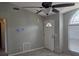 A bright living room featuring ceramic tile, a ceiling fan, a big window, and a white front door at 2798 Beckwith St, Deltona, FL 32738