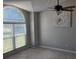 A living room featuring ceramic tile, a ceiling fan, a big window, and light-grey walls at 2798 Beckwith St, Deltona, FL 32738