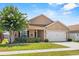 Inviting home with a manicured lawn, a flowering tree, and an attached two-car garage at 2980 Cool Breeze Cir, St Cloud, FL 34769