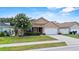 Charming single-story home with a well-kept lawn, complemented by a flowering tree at 2980 Cool Breeze Cir, St Cloud, FL 34769