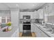 Bright kitchen features stainless steel appliances, double basin sink, and decorative tile backsplash at 2980 Cool Breeze Cir, St Cloud, FL 34769