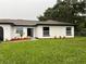Well-manicured lawn, modern landscaping, and freshly painted home with a black front door at 3 Spur Ct, Kissimmee, FL 34743