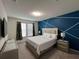 Bright bedroom featuring a striking accent wall and neutral furnishings for a modern style at 3012 Mahalo Dr, Davenport, FL 33897