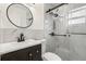 Modern bathroom featuring a glass shower with black hardware and a stylish black framed round mirror at 306 Modest St, Lakeland, FL 33805