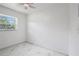 Bright bedroom with a modern ceiling fan, a large window, and elegant marble-look tile flooring at 306 Modest St, Lakeland, FL 33805
