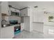 Modern kitchen featuring white cabinets, stainless steel appliances, and adjacent living area at 306 Modest St, Lakeland, FL 33805