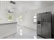 Bright kitchen featuring new stainless steel refrigerator, white cabinets and marble tile floors at 306 Modest St, Lakeland, FL 33805