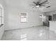 Sunlit living area with tile floors, ceiling fan, and a stainless steel refrigerator visible in the kitchen area at 306 Modest St, Lakeland, FL 33805