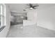 Open concept living space showcasing tile floors, a ceiling fan, with a view to the adjacent, modern kitchen at 306 Modest St, Lakeland, FL 33805