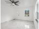 Bright living room with new tile flooring, ceiling fan and a view of the front yard through the window at 306 Modest St, Lakeland, FL 33805
