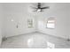 Bright living room featuring new white tile flooring, a modern ceiling fan, and natural light from the windows at 306 Modest St, Lakeland, FL 33805