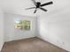 Bright bedroom featuring a ceiling fan and a window overlooking the neighborhood at 3115 Avenue U Nw, Winter Haven, FL 33881