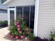 Exterior view showcasing a cozy screened lanai, complemented by colorful flowers at 3328 Davis Ter, The Villages, FL 32163