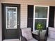 Welcoming front door with decorative glass and a window framed by black shutters at 3328 Davis Ter, The Villages, FL 32163