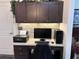 Modern, built-in office area with dark cabinetry, computer, and printer at 3328 Davis Ter, The Villages, FL 32163