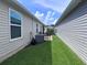 Lush side yard featuring green grass and a patio area at 3328 Davis Ter, The Villages, FL 32163