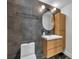 Bathroom features grey tile, a wood vanity with drawers, modern fixtures, and an oval mirror at 337 Cathcart Ave # 6, Orlando, FL 32803