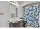Bright bathroom features a single vanity, mirror, and tub/shower combo with a floral shower curtain at 337 Cathcart Ave # 6, Orlando, FL 32803