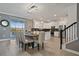 Open-concept dining area with a rustic table, seating for eight, and a seamless transition to the kitchen at 4185 Paragraph Dr, Kissimmee, FL 34746