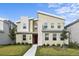 Modern two-story home with a unique architectural style, manicured lawn, and a vibrant red front door at 4185 Paragraph Dr, Kissimmee, FL 34746