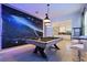 Fun game room with a custom space themed mural, pool table, tile floors, bar table and chairs at 4185 Paragraph Dr, Kissimmee, FL 34746