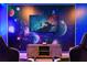 Themed game room showcasing wall art, gaming chairs, and a cabinet with a tv for entertainment at 4185 Paragraph Dr, Kissimmee, FL 34746