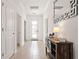 Bright hallway with tile flooring, a modern console table with lamp, and decorative mirror at 4185 Paragraph Dr, Kissimmee, FL 34746