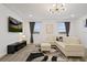 Bright living room with a white sectional sofa, flat-screen TV, and modern light fixture at 4185 Paragraph Dr, Kissimmee, FL 34746