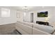 Living room with a white sectional sofa, flat-screen TV, and neutral carpet at 4185 Paragraph Dr, Kissimmee, FL 34746