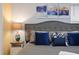 Close up on a king bed with blue pillows and bedside lamp at 4185 Paragraph Dr, Kissimmee, FL 34746