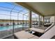 Enclosed pool area with comfortable lounge seating and a view of a peaceful pond at 4185 Paragraph Dr, Kissimmee, FL 34746