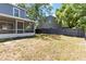 A spacious backyard featuring a wooden fence, lush greenery, and the house with screened in porch at 4447 Brook Hollow Cir, Winter Springs, FL 32708