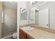 Bathroom with wood vanity, granite countertops, single sink, and walk-in shower with beige tile at 4447 Brook Hollow Cir, Winter Springs, FL 32708